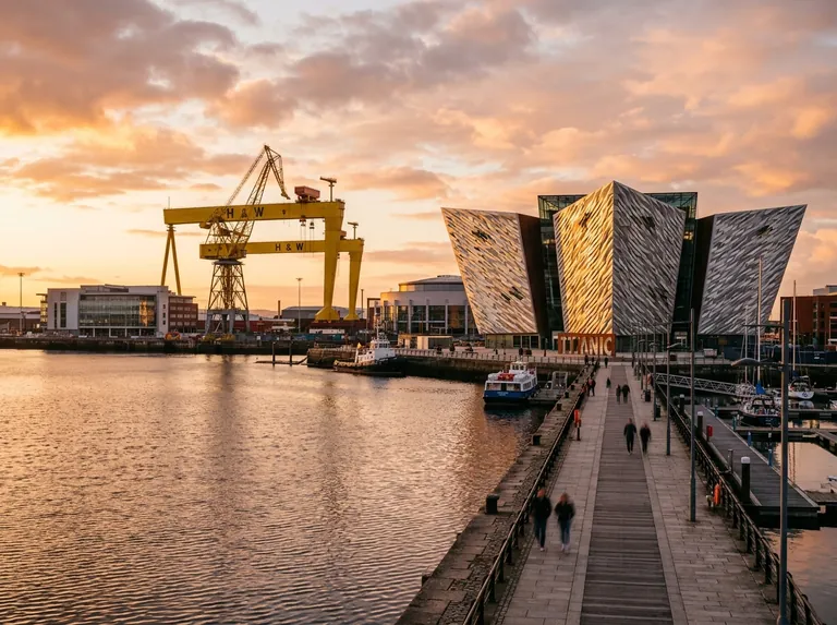 Belfast at golden hour with the Titanic Belfast building and the harbour cranes